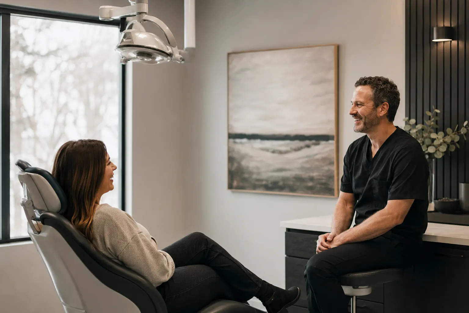 A dentist and an advisor talking beside the chair.